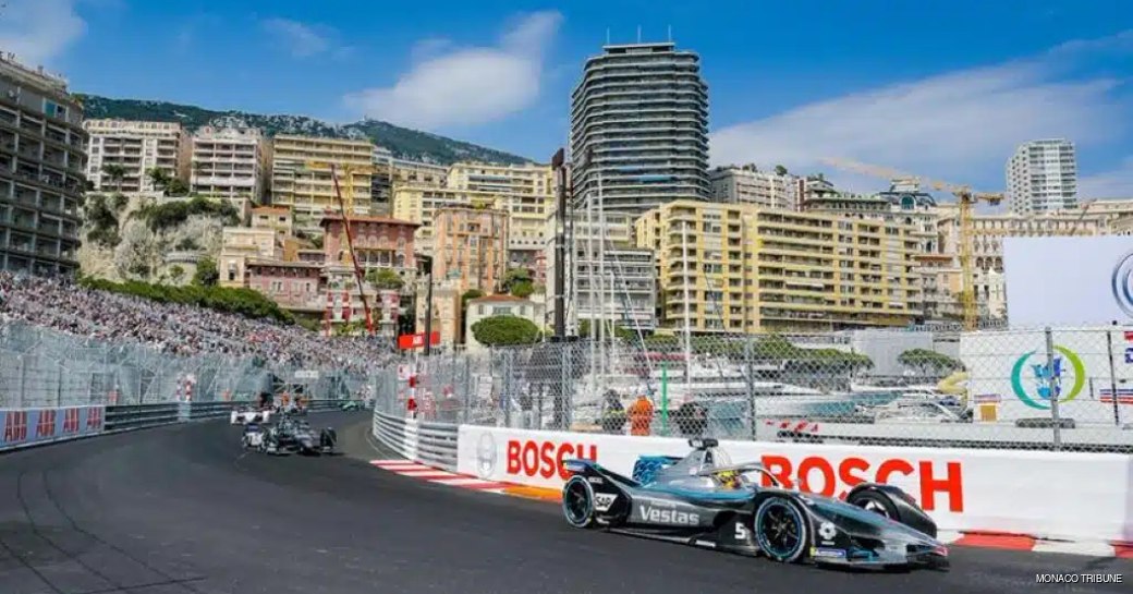 Formula E racer on the Monaco track, with Port Hercule in the background.