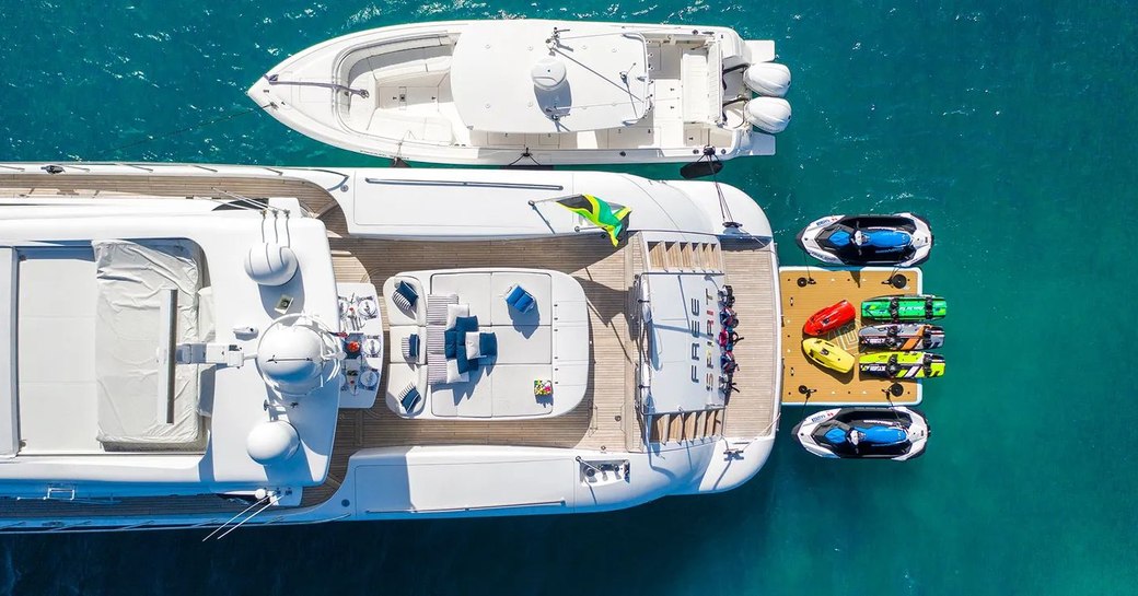 aerial image of luxury yacht free spirit, with toys laid out in the water and tender alongside