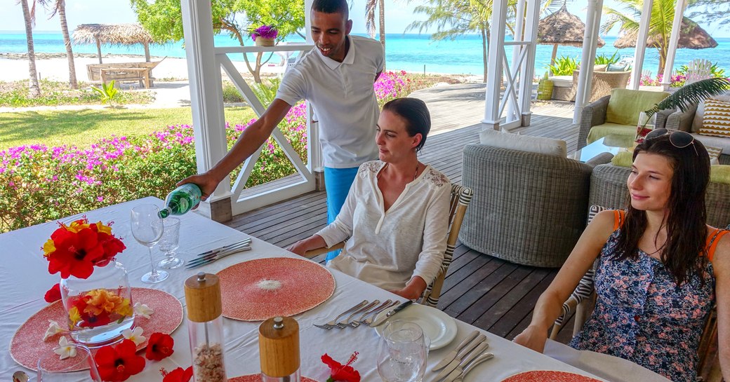 man pours drinks at alfresco dining table on thanda island