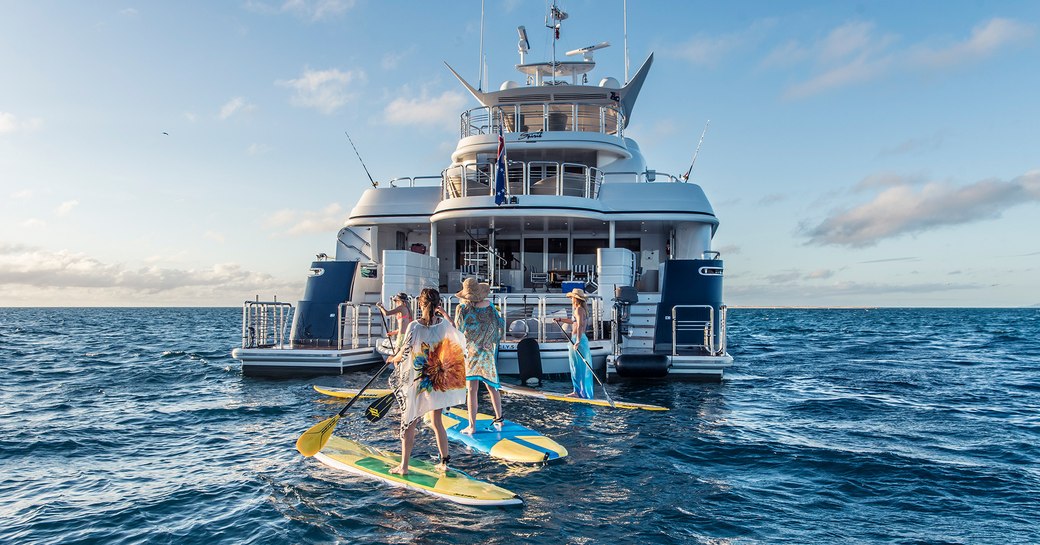 charter guests paddelboard in the waters around spirit