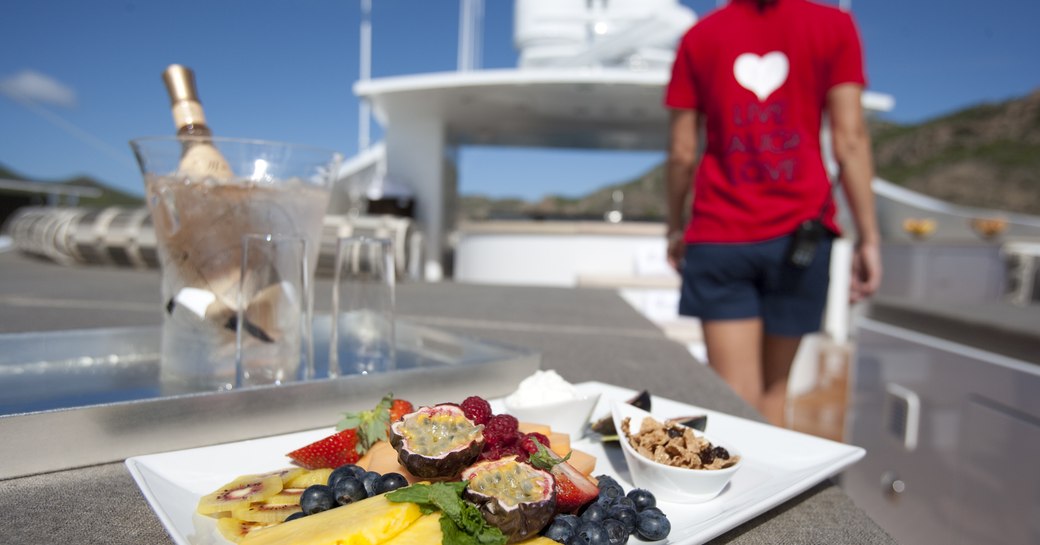 fruit plate being served of sundeck of luxury yacht