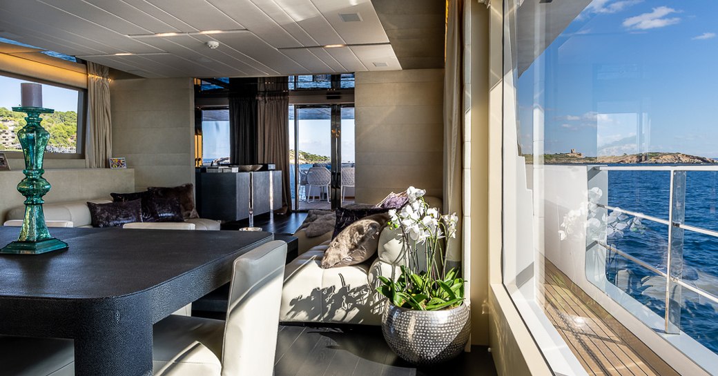 Main salon with elegant table and adjacent window on motor yacht Cinquanta 50