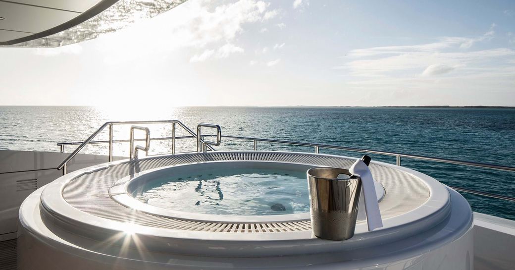 the 8 man jacuzzi on supeyracht HOME overlooking the sun setting behind a Caribbean horizon