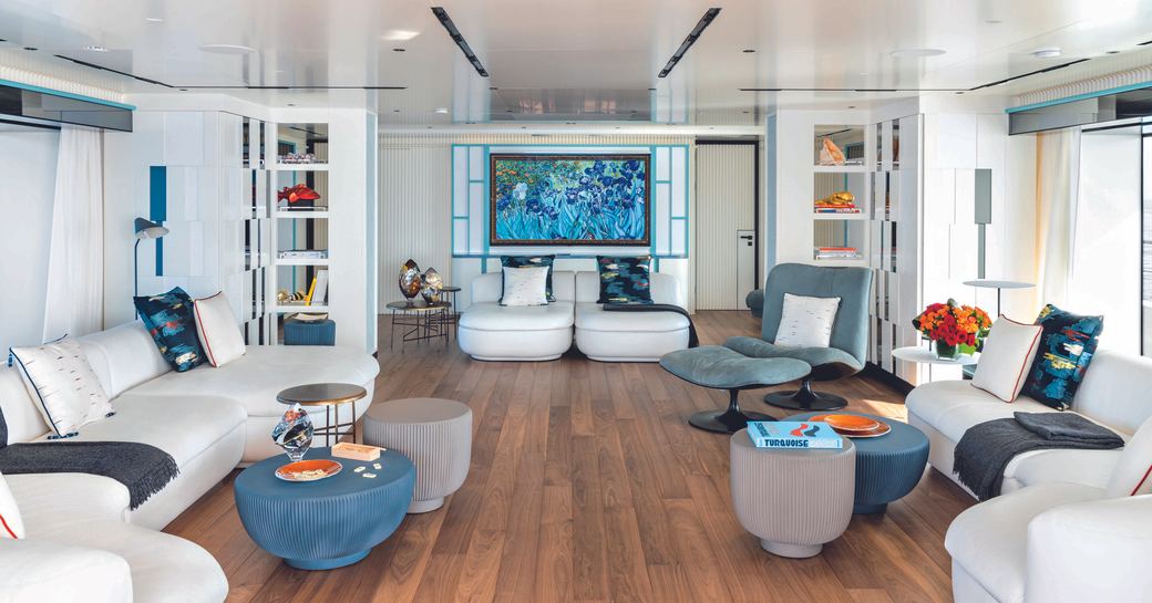 Interior lounge area onboard charter yacht RIO with white sofas and circular coffee tables