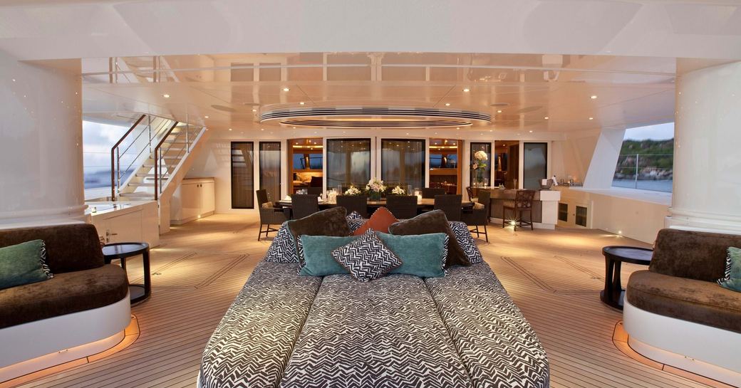Exterior lounge area with ample seating and a sunpad onboard charter yacht HEMISPHERE