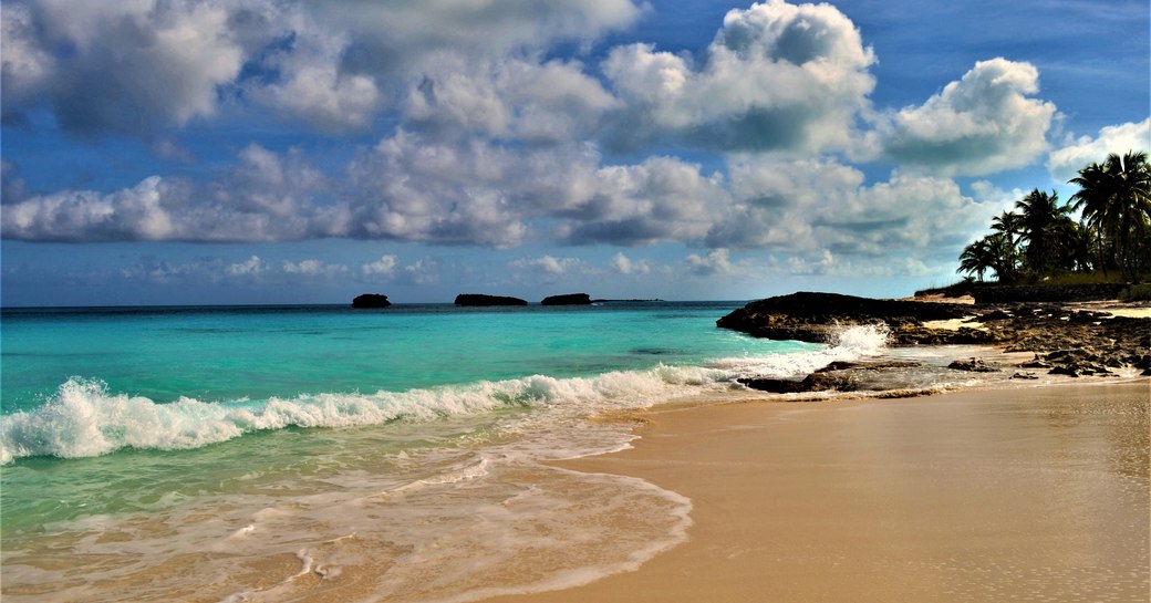 Clear blue water lapping the sandy beach in the Exumas