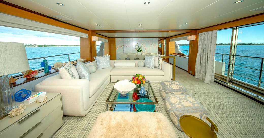 Main salon with plush seating and large windows onboard luxury yacht charter REHAB