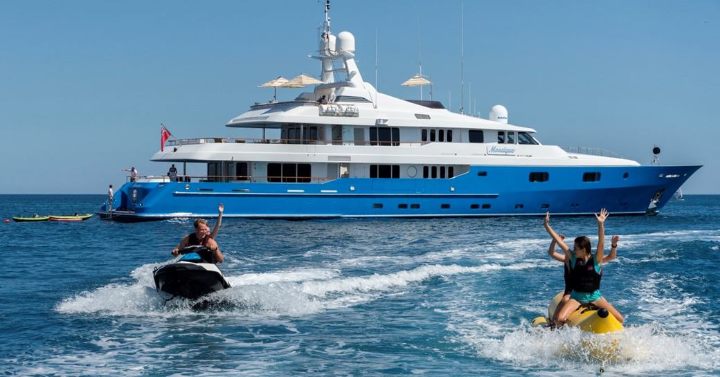 Charter yacht MOSAIQUE at anchor with charter guests having fun on water toys