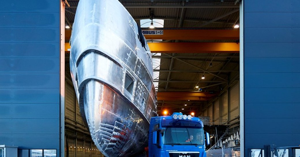 The shiny hull of Erica in the doorway to the Heesen shipyard