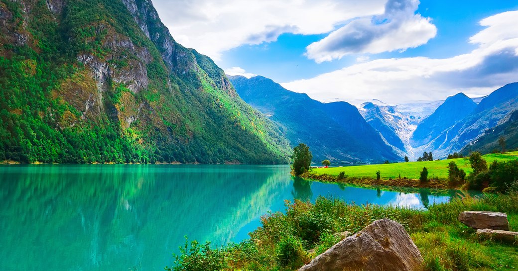 Norwegian landscape with Nordfjord fjord, mountains, flowers and glacier in Olden, Norway