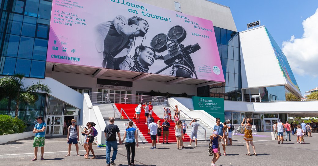 Entrance to Cannes Lions event, Palais de Festivals with red carpet on stairs and visitors gathering outside.