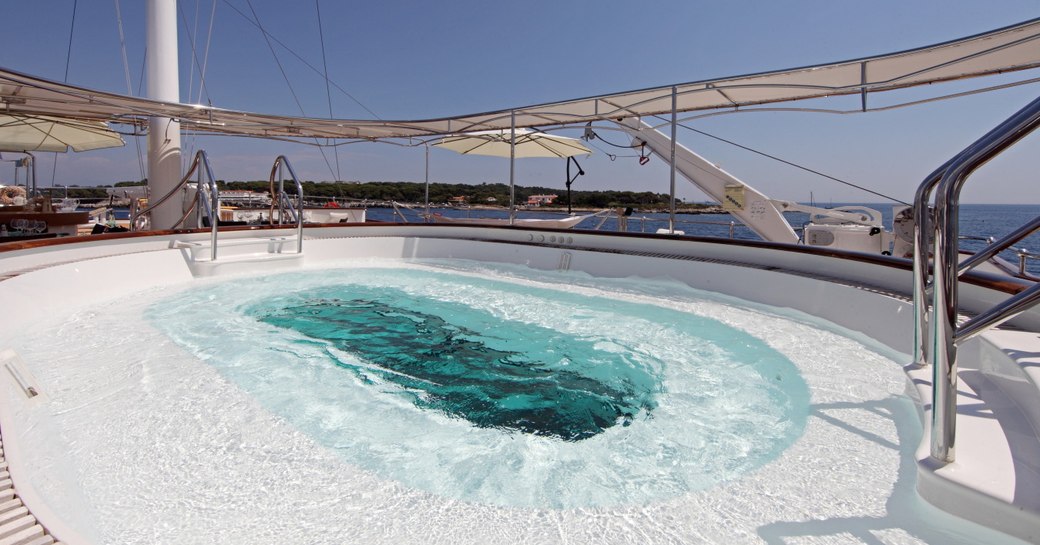 Poolside view of the large Jacuzzi on the deck of superyacht Sherakhan