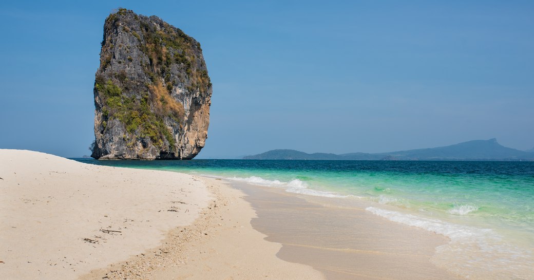 White sand beach on Ko Poda island, with rock jutting out of sea