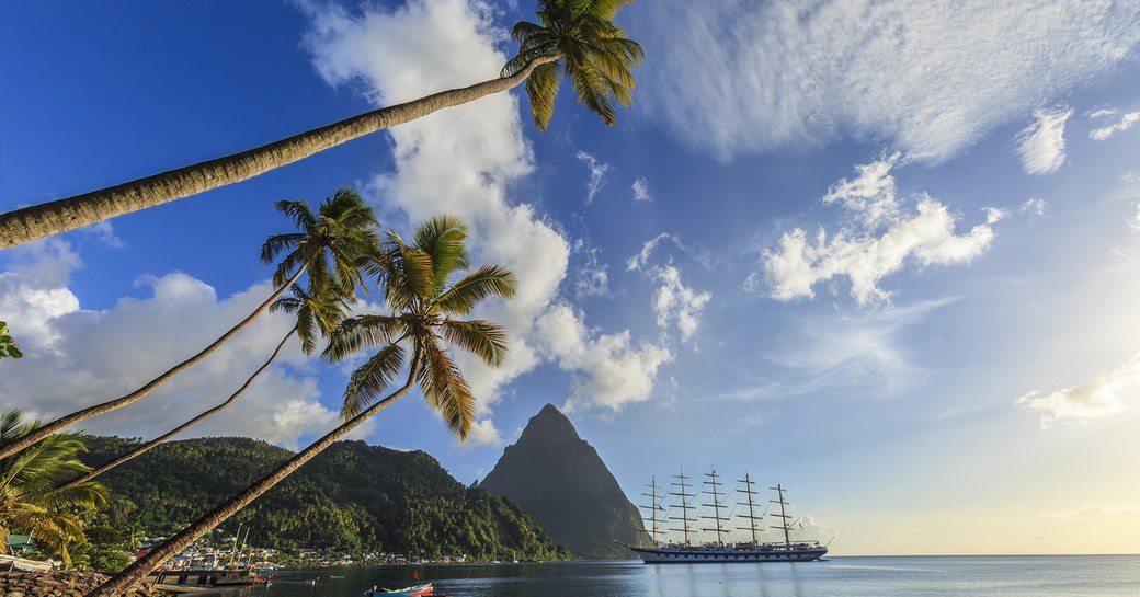 pitons of st lucia with palm trees and sandy beach in foreground