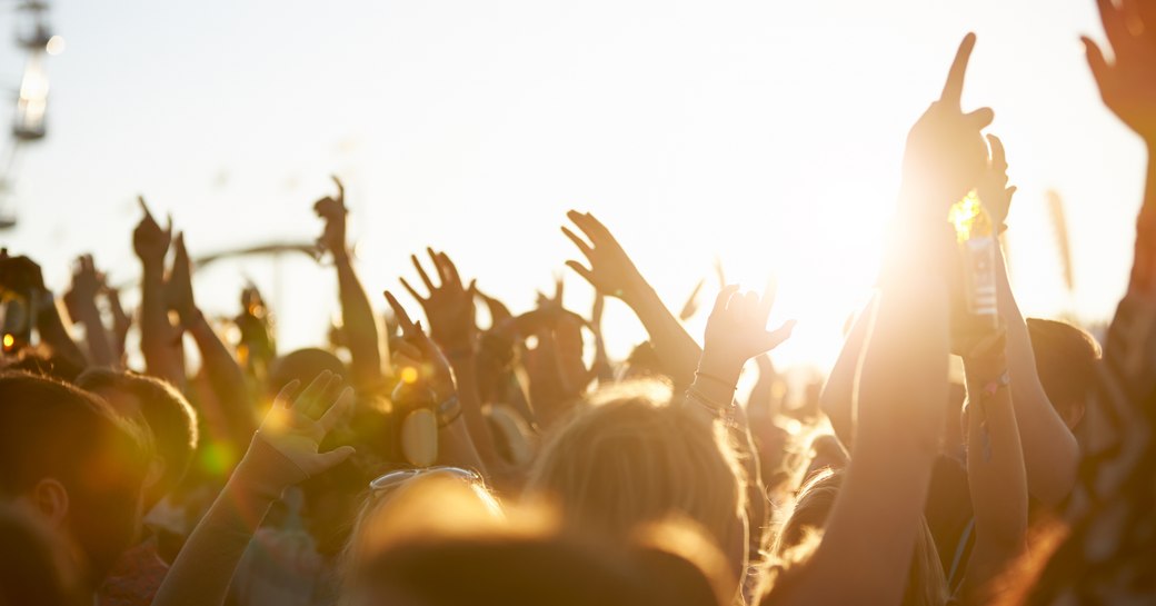 People's hands waving in air during a festival.