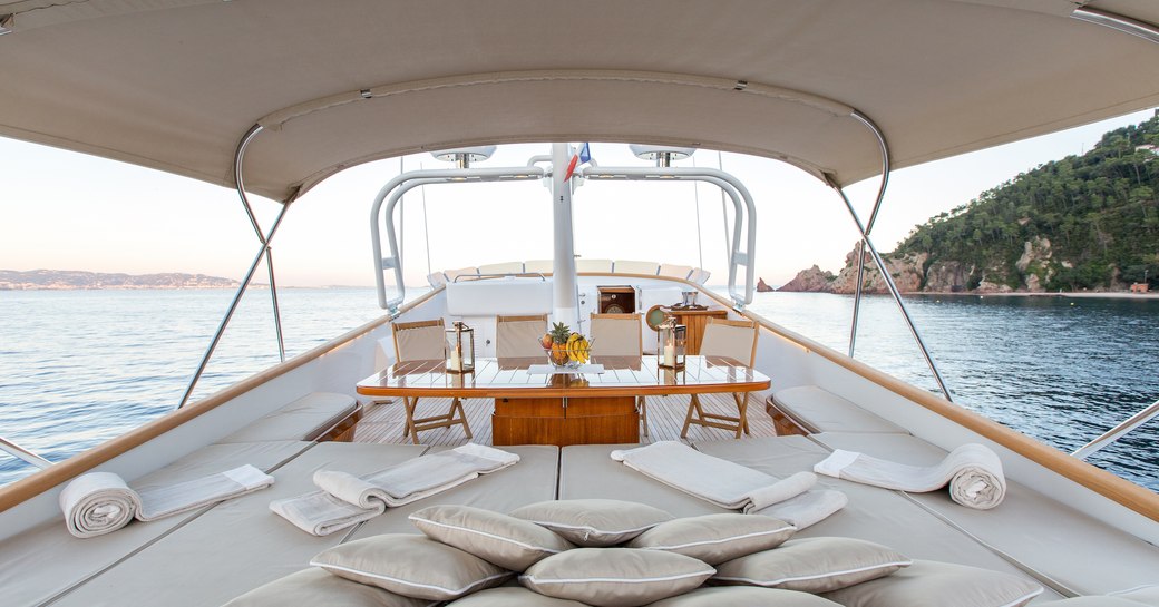 sunbathing area and alfresco dining area beyond on board motor yacht LIBERTUS