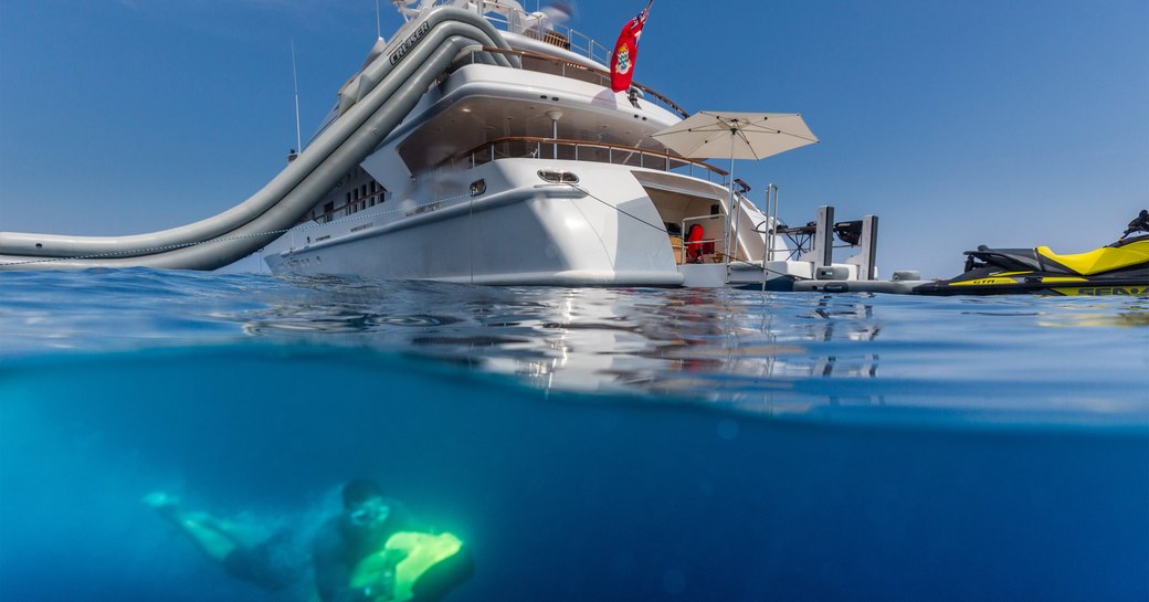 charter guest on seabob as luxury yacht Air anchors alongside water toys and water slide