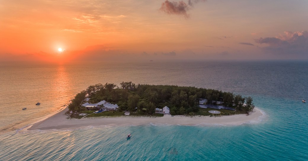 sun setting over thanda island aerial shot