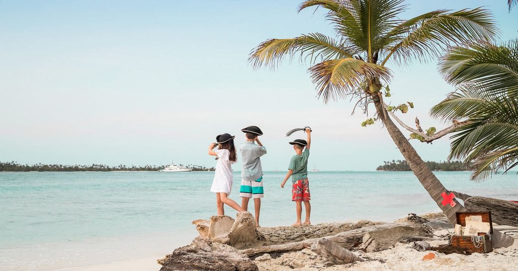 children dressed as pirates wave at superyacht