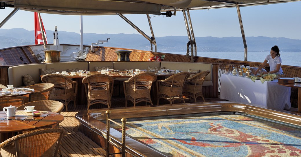 Alfresco area with mosaic pool on megayacht Christina O, with alfresco dining set-up