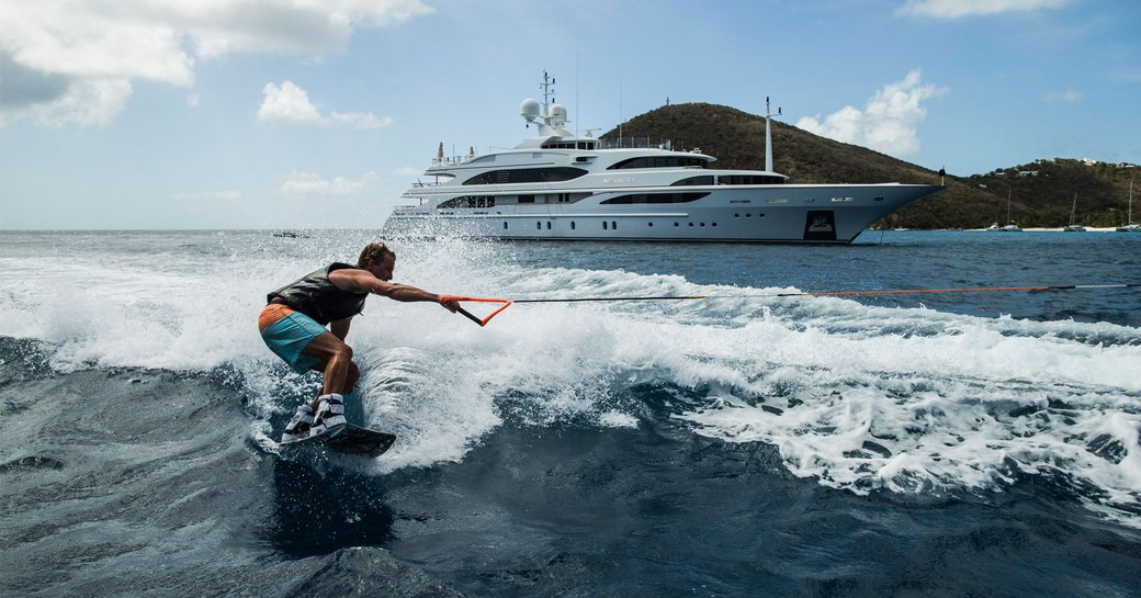 luxury yacht MEAMINA anchors as charter guest enjoys water toys