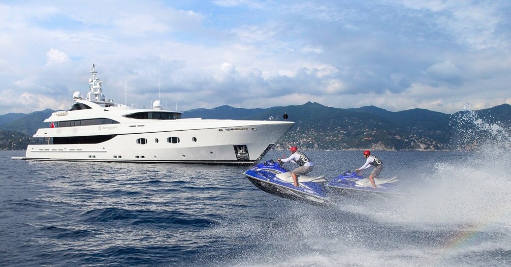 motor yacht TURQUOISE anchors on charter as guests explore the area on jet skis