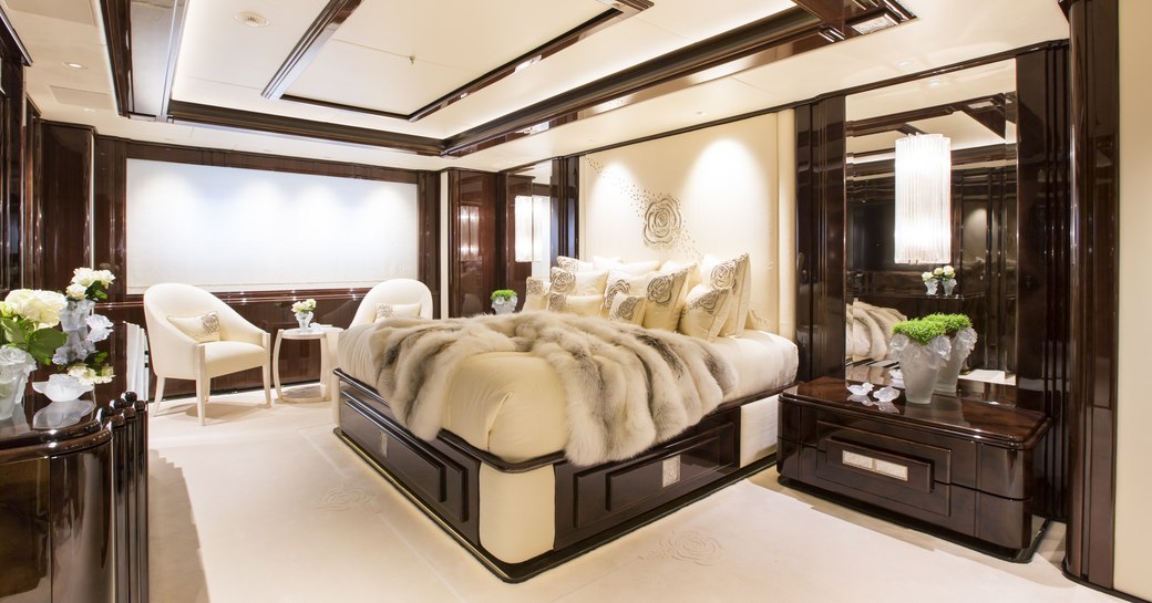 Master cabin onboard charter yacht ILLUSION V, central berth facing forward with seating in the background.