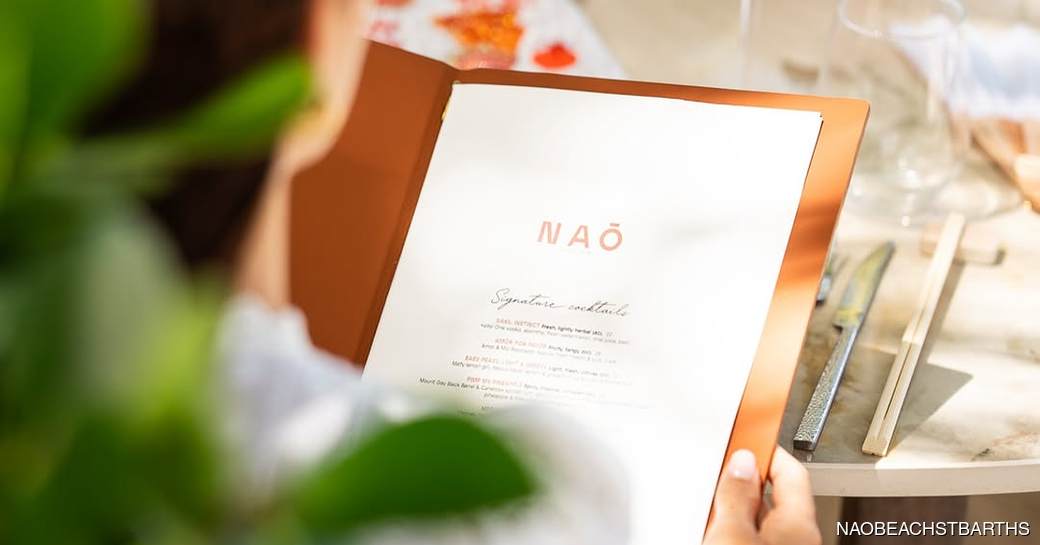 Femal yacht charter guest browsing a Nao Beach menu
