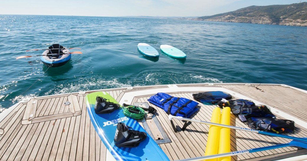 Overview of the swim platform onboard private yacht charter MEDITERRANI IV, with a variety of water toys onboard and in the water adjacent