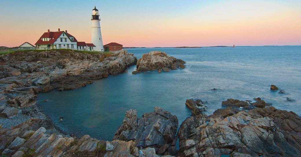 lighthouse on the coast of new england a popular luxury yacht charter vacation destination