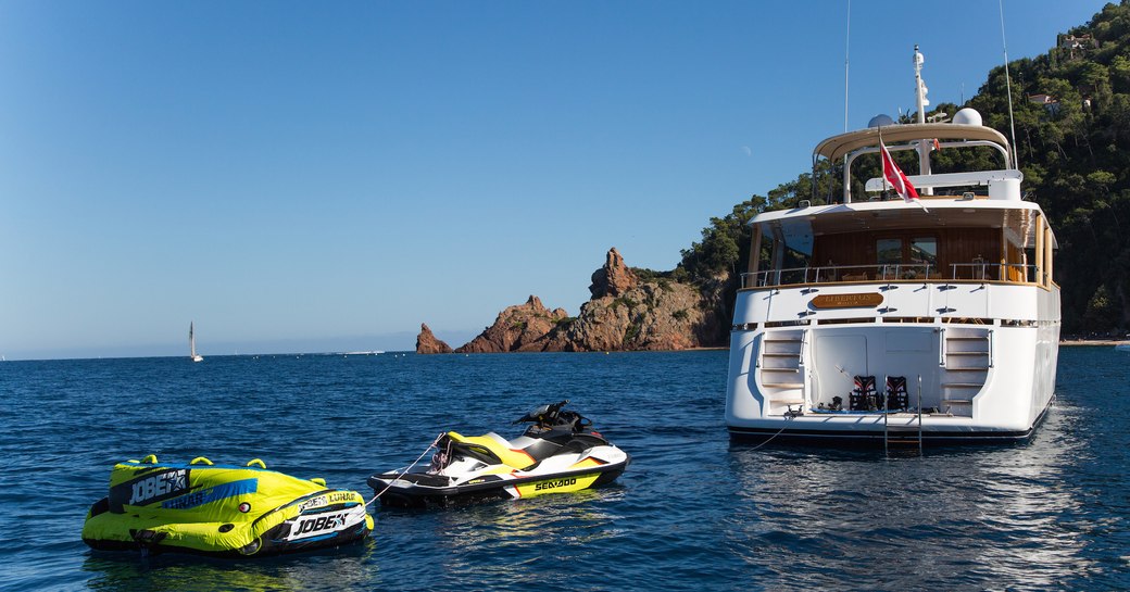 View of the stern of luxury yacht LIBERTUS alongside water toys