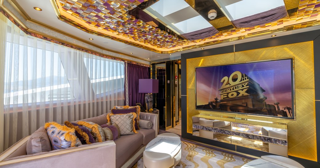 Large wall mounted TV screen facing plush seating onboard Superyacht LEONA.