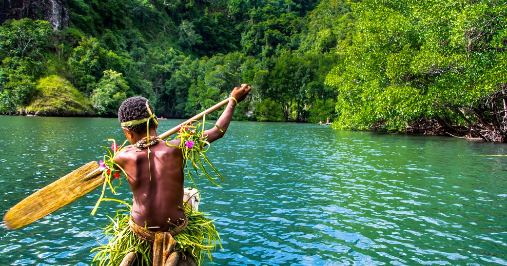 boy rows boat in papua new guinea