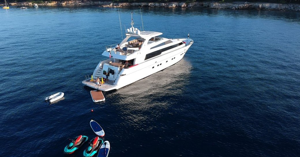 sanlorenzo motor yacht panthours at anchor with charter guests on swim platform playing with water toys