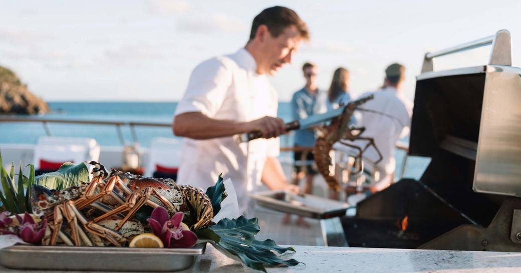 A chef cooking at a BBQ onboard a yacht