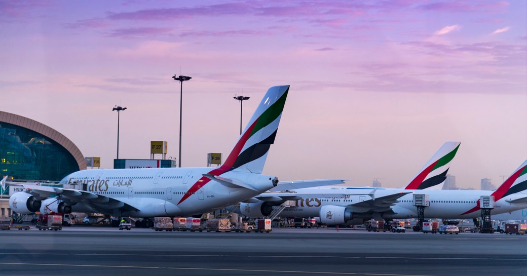 planes lined up on the runway at Abu Dhabi International Airport as dusk falls