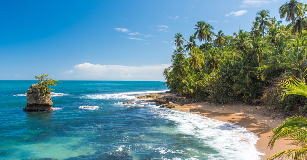 beach in costa rica with jungles and bright blue sea