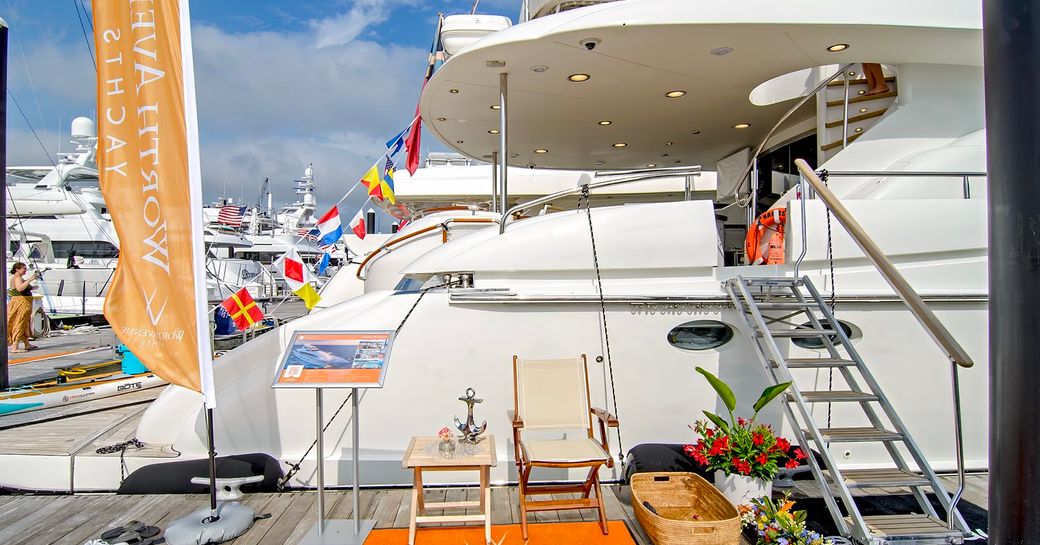 Display of charter yachts with orange floor mat reading Worth Avenue Yachts