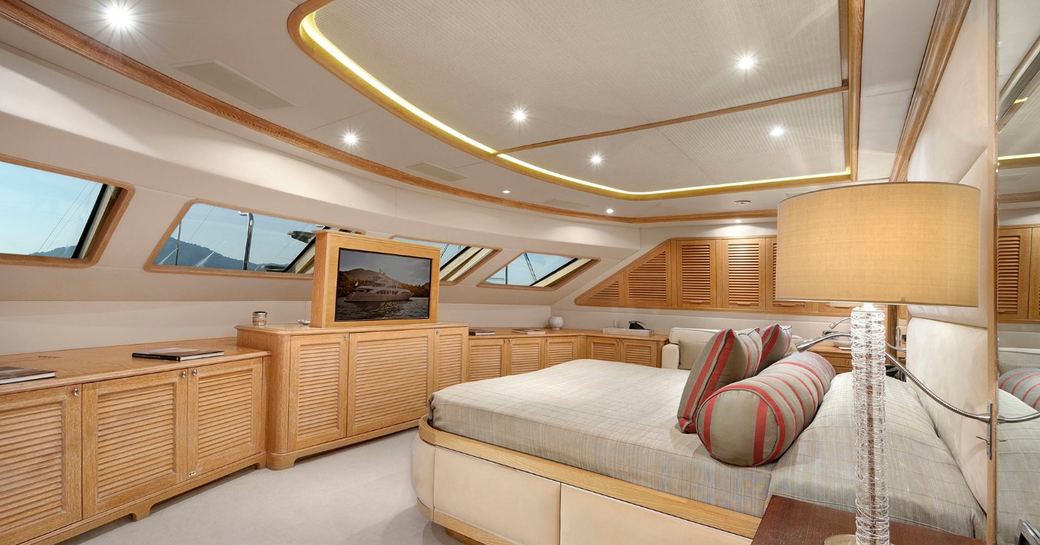 Overview of master cabin with central berth and multiple windows onboard charter yacht QUEST R