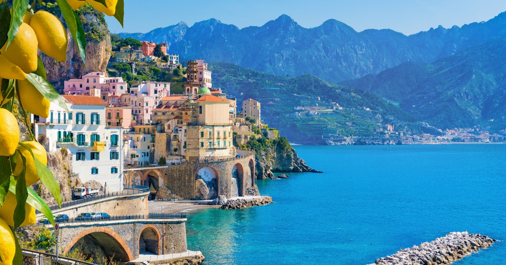 Overview of an Italian coastline with buildings in the cliff face and lemons