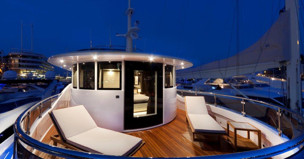 Superyacht GATSBY owners private balcony at night with sunloungers on deck