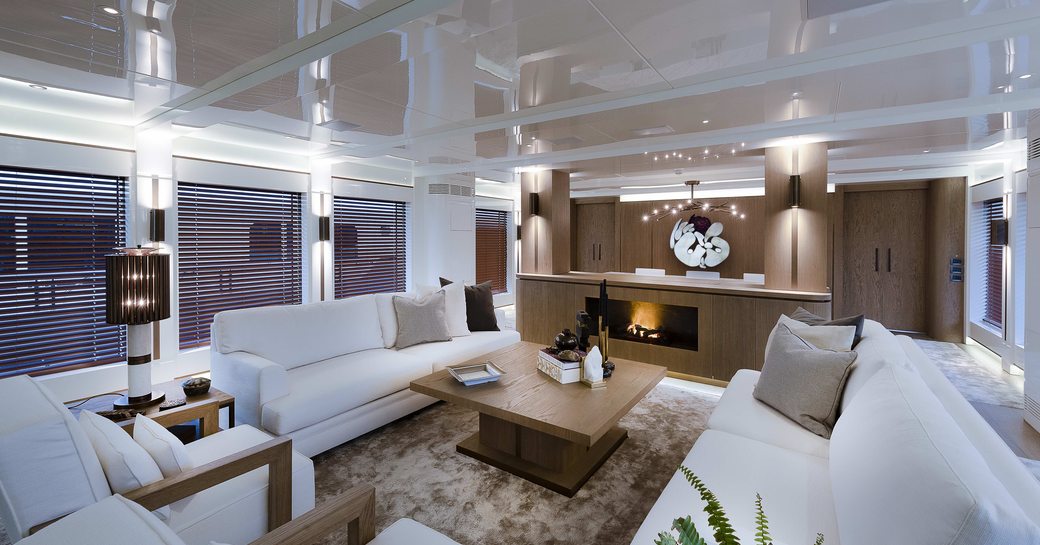 main salon with sumptuous seating and fireplace on board superyacht Liquid Sky 
