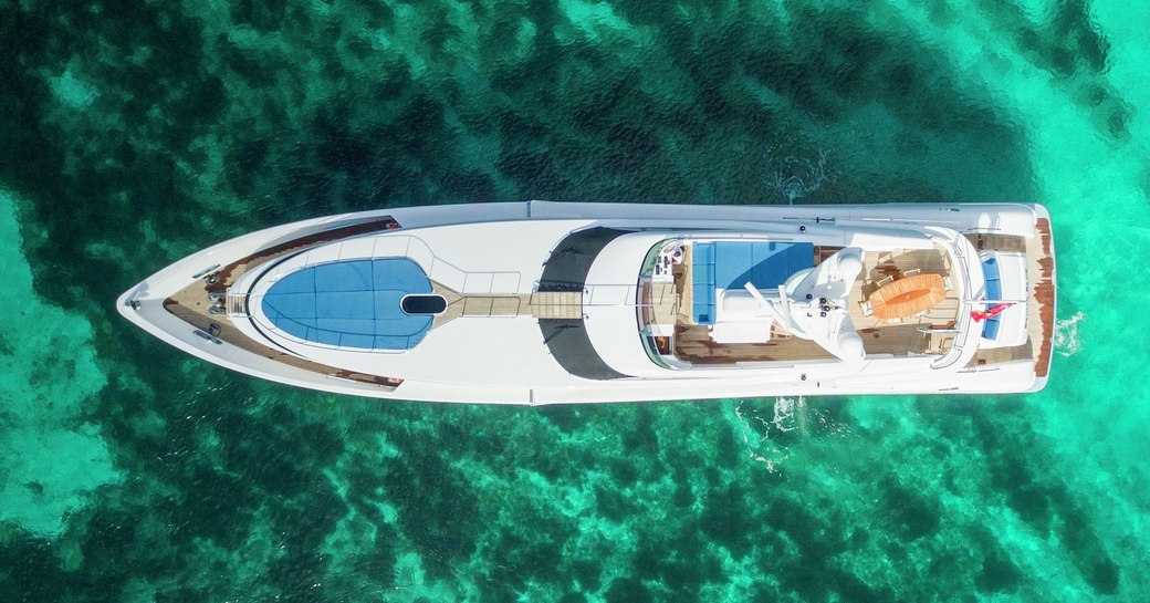 aerial view of luxury yacht Benita Blue as she cruises through turquoise waters of the Balearic Islands on a private yacht charter