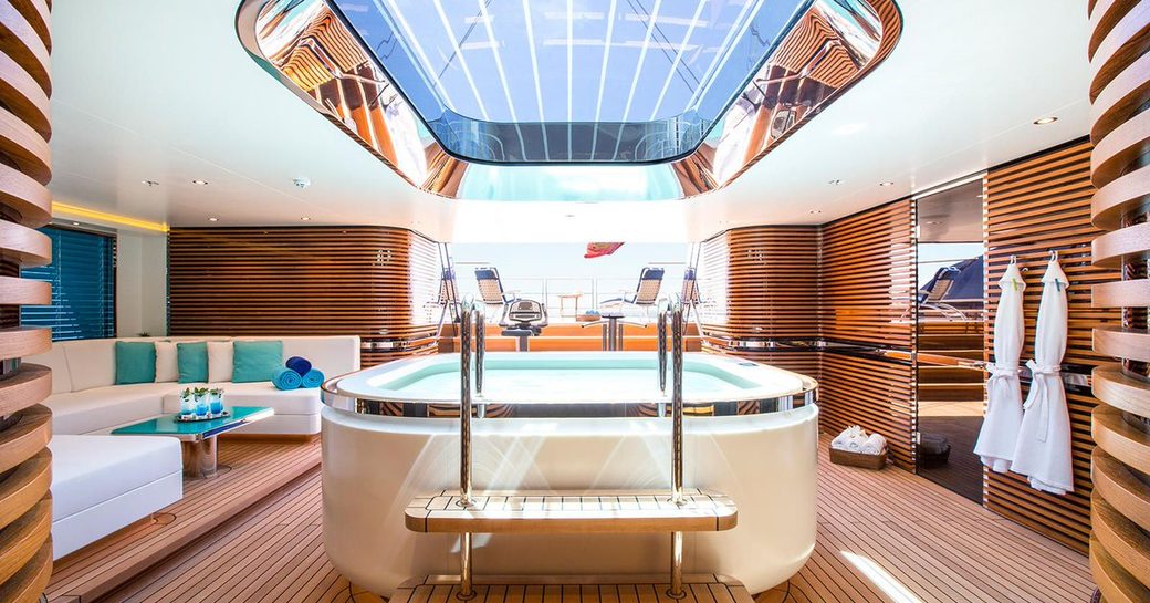 A swimming pool and comfortable furnishings in the spa of a superyacht