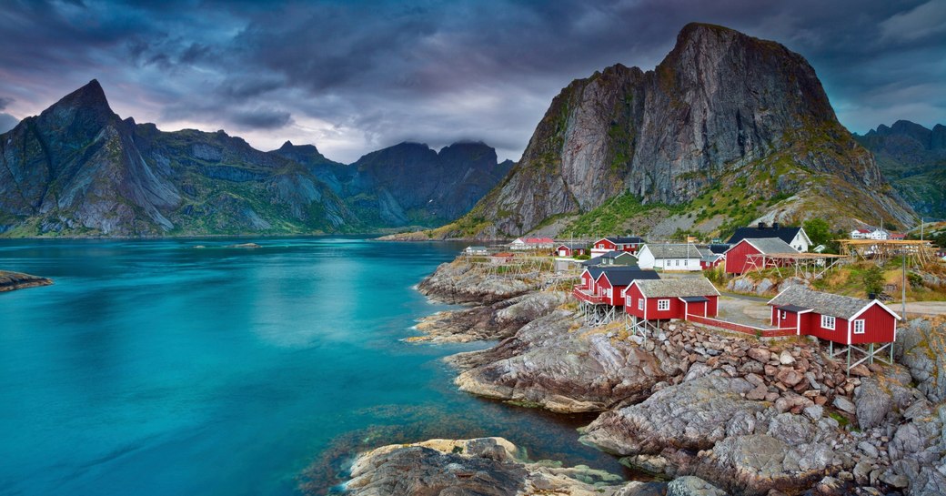 red houses perch on the water's edge in the Lofoten Islands, Norway
