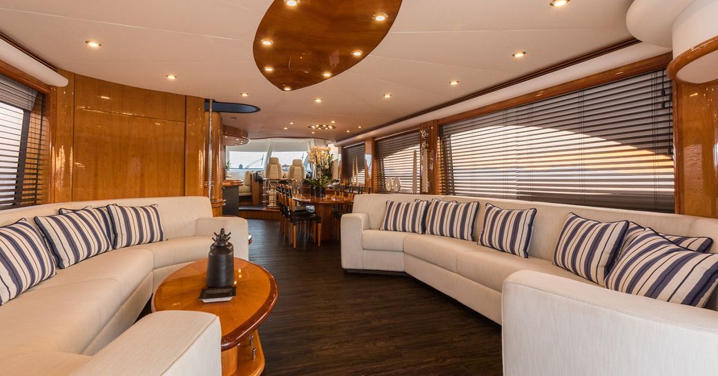 Overview of the main salon onboard charter yacht Winning Streak 2, lounge area in thr foreground with dining area aft