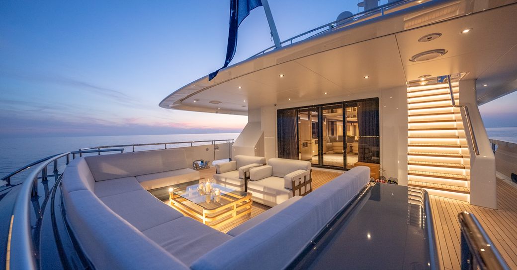 Aft main deck onboard charter yacht RELIANCE, alfresco dining and lounge area, with panoramic views of the sea.
