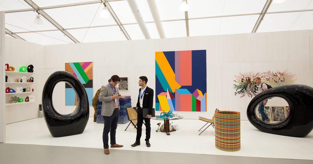 two men at Art Basel in Miami discussing the curation of a gallery