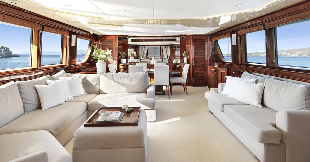 Main salon onboard charter yacht Mia Zoi, extensive lounge area forward with a formal dining area aft