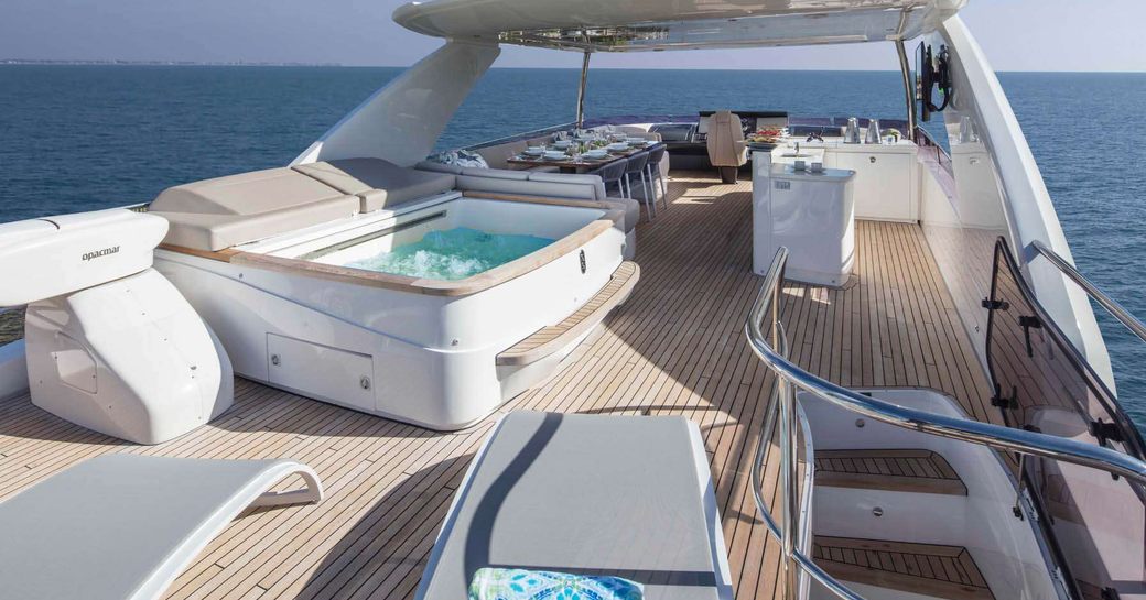 the sumptuous and luxury flybridge of superyacht hot pursuit fit with jacuzzi, sunpads, and bar